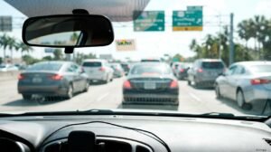 Navigating heavy Miami highway gridlock using a SunPass sticker to avoid rental car toll fees.